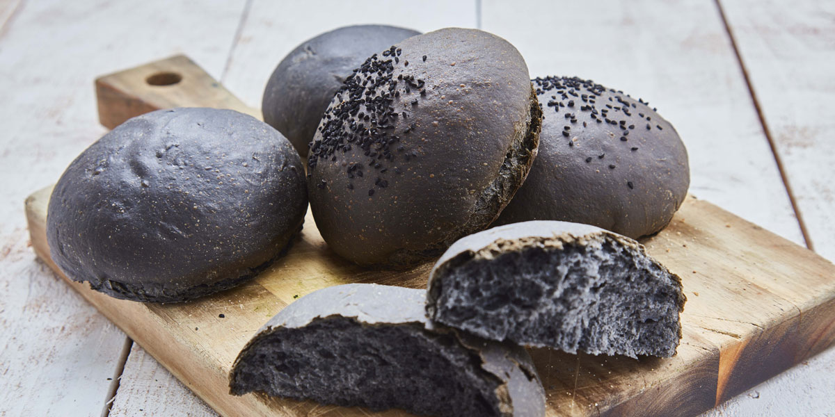 Charcoal Brioche Buns served on a wooden board