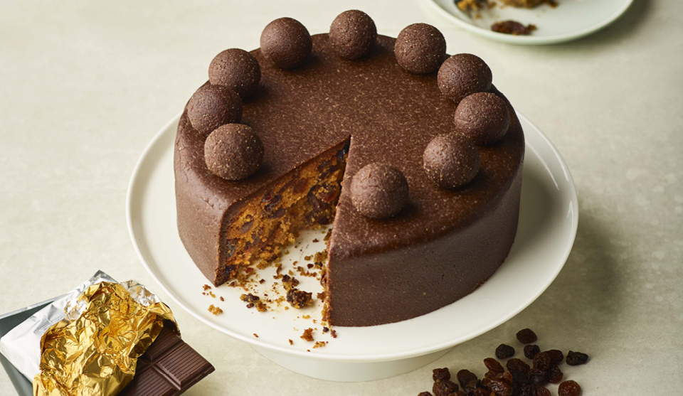 Simnel Cake with a Twist served on a white dish, with a slice removed to see the filling